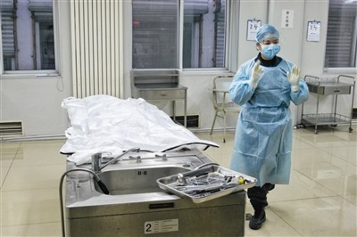 一位女法医在解剖台旁边准备工作.本版摄影/新京报记者 王嘉宁