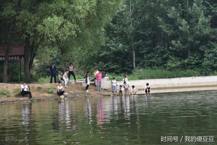 很多小朋友捞鱼玩累了在湖边洗脚戏水.